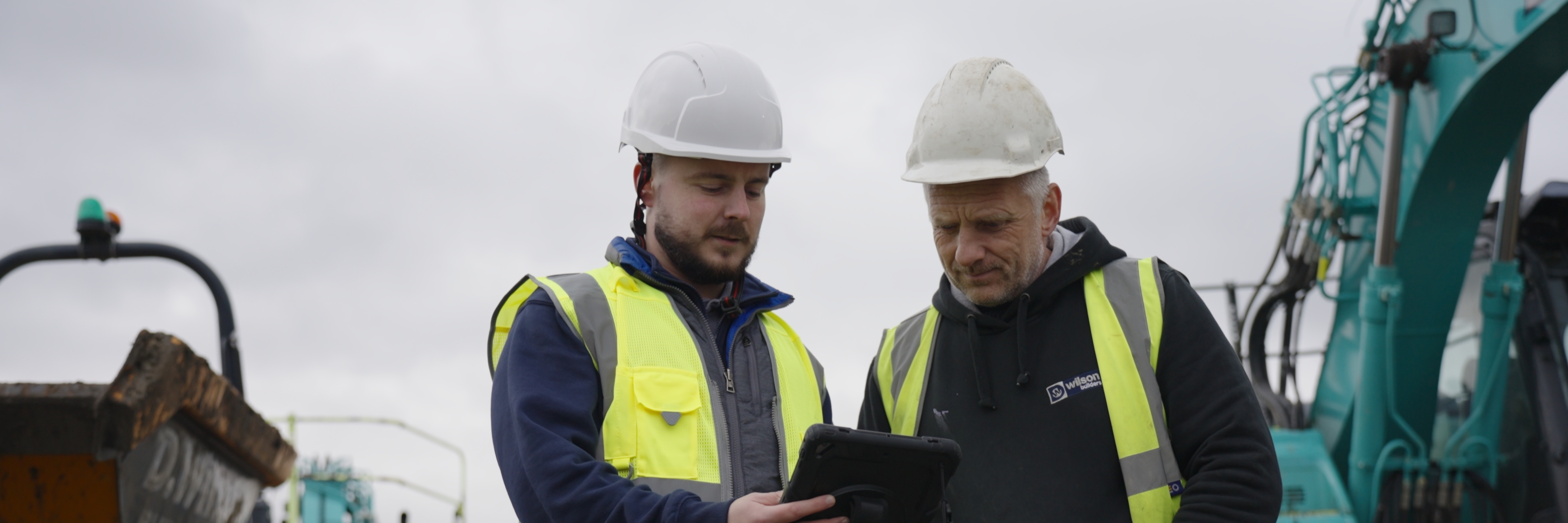 Two Olrose site staff in hi-vis reviewing footage on a tablet on site